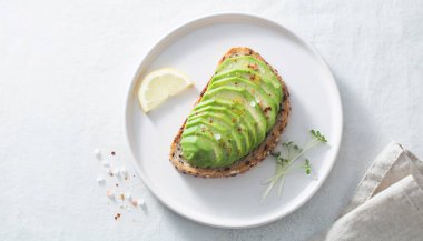 Dilimlenmiş Avokado Tostu Beyaz Tabakta Doğal Işık Gölgesi ile