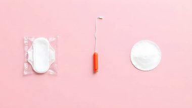 Kadın sağlığının temel gerekliliklerinin kısa bir gösterimi, yumuşak pembe arka planda bir adet bardağı, hijyenik ped ve doğum kontrol diyaframı içeriyor. Bu düzenleme, kadın hijyeni ve üreme bakımı için çeşitli seçenekleri vurgular, farkındalıkları teşvik eder