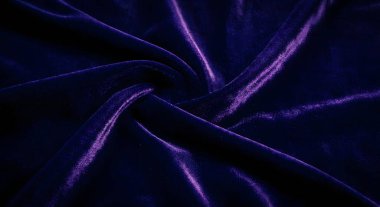 Koyu mor kadife kumaşın zengin dokusunu ve zarif kıvrımlarını gösteren yüksek kaliteli yakın çekim görüntüsü. Bu lüks malzeme yumuşak gölgeler ve röfleler içerir, onu moda veya iç tasarım için mükemmel kılar..