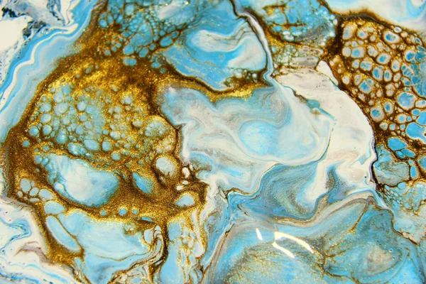 Beautiful abstract background. Golden and blue mixed acrylic paints. Fluid art. Liquid marble. Contemporary art.