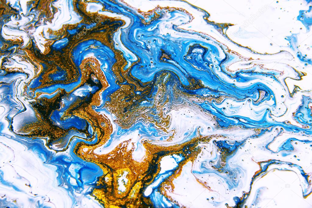 Beautiful abstract background. Golden and blue mixed acrylic paints. Fluid art. Liquid marble. Contemporary art.