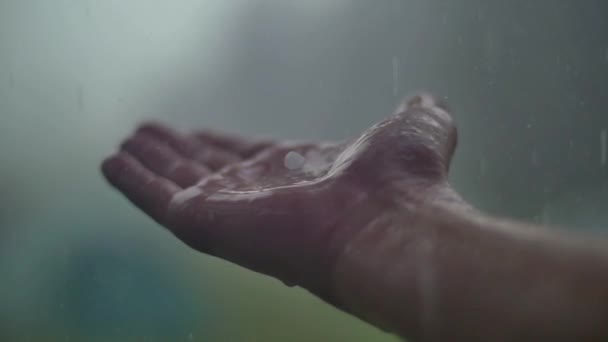 Mano de hombre bajo la lluvia y el granizo — Vídeos de Stock
