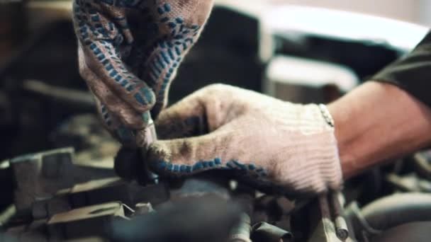 Maestro en guantes desenrosca el perno con una llave de plata de cerca — Vídeo de stock