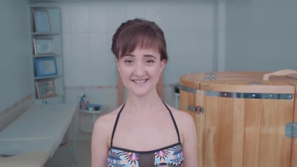 Dívka v plavkách top v lázeňském salonu detailní. Cedr fytobarrel v pozadí. — Stock video