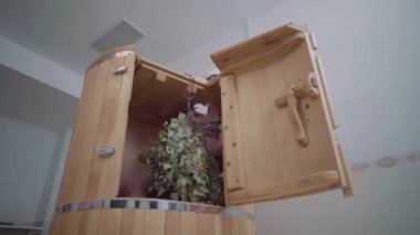 Açık sıcak sedir fideto fıçısı kaybı. İçeride kız oturuyor ve banyo için süpürge asıyor.