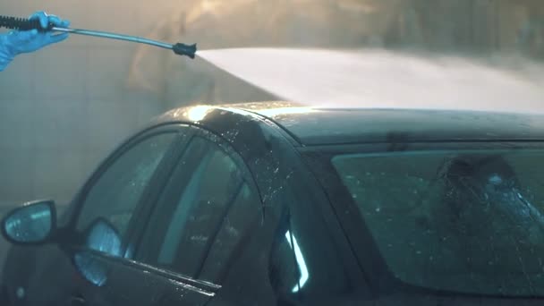 Master πλένει καλά την οροφή του sedan με σωλήνα νερού σε υπηρεσία σπάνια closeup — Αρχείο Βίντεο