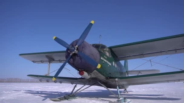 Vliegtuig tweedekker An2 landde op sneeuw. Blauwe heldere lucht achtergrond. In focus. — Stockvideo