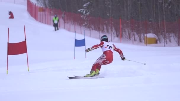 Αθλητής κυλά κομμάτι με ταχύτητα για σκι παρακάμπτοντας σημαίες κολλήσει στο χιόνι αργή κίνηση — Αρχείο Βίντεο