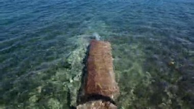 Sakin Akdeniz sularının altında, güneşin altında görünen beton bir yapı vardır. Denizin mavi berraklığı her detayı gözler önüne seriyor..