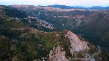 Dağ vadisi volkanik bir oyuk gibi görünüyor. Yunanistan 'ın güney Avrupa genelinde bulunan kırsal bir bölgede bulunan Lagkadia amfiteatral köyünü kucaklayan dik kayalık duvarları vardır..