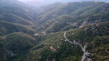 Yüksek yeşil dağlar arasında sarmal tehlikeli bir yol uçurumun kenarında uzanırken sarp bir uçurum açılır ve Avrupa 'da Yunanistan' da bulunan bu engebeli Akdeniz manzarası boyunca çarpıcı manzaralar sunar..