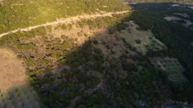 Dik bir dağ yamacında vahşi ormanlar, alçalan zeytinlikler ve Yunanistan, Avrupa 'daki uzak bir vadinin yukarısındaki tepenin yakınında uzun düz bir yol bulunur..