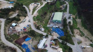 Yunanistan, Avrupa 'daki bitkisel yamaçlara entegre endüstriyel malzeme taşıma ve depolama yapılarının sinematik görüntüleri.