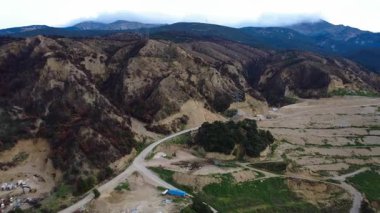 Adımlı taş ocağı seviyelerine, yanmış bitki örtüsüne, erişim yollarına, direklere ve inşaat araçlarına sahip bir dağ kazı bölgesi, Yunanistan ve Avrupa 'da güçlü bir insan etkisi gösteriyor.