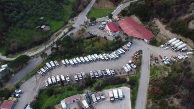 Yunanistan ve Avrupa 'daki yoğun hizmet altyapısı kapsamında koordineli belediye lojistiği, asfaltlama rotaları ve çevresel etkileri gösteren geniş bir hava genel görünümü.