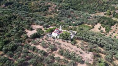 Kırmızı kubbeli ve süslü çan kulesiyle ıssız beyaz kilise yerleşim yerlerinden uzak geleneksel zeytin ağaçlarının arasında kuru bir yamaçta duruyor. Yunanistan ve Avrupa 'da sakin kırsal ortam.