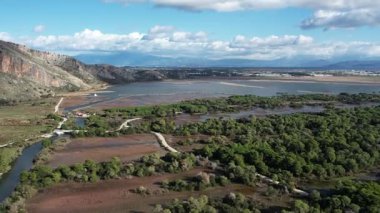 Geniş hava manzarası yoğun çam ormanlarını, dolambaçlı yolları, bataklık sularını ve ağır bulutların altındaki dramatik dağları ortaya çıkarır. Yunanistan ve Avrupa 'da dokunulmamış ekosistem manzarası.