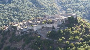 Yüksek hava manzarası, Yunanistan ve Avrupa 'daki stratejik bir dağ vadisine hakim savunma duvarları, kiliseler ve katmanlı ortaçağ yapılarına sahip Mystras' ın güçlendirilmiş kalıntılarını gözler önüne seriyor..