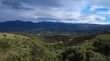 Geniş bulutlu gökyüzünün altında geniş bir vadi açılıyor. Dağlar, ekilmiş düzlükler ve orman vadileri Yunanistan ve Avrupa 'nın vahşi kırsal kesimlerinde..