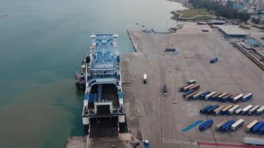 Limandaki liman terminalinde konteynırlar ve liman altyapısı sanayi limanını doldururken kamyonlar arka rampadan geçiyor..