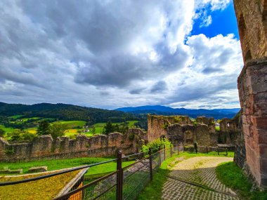 Düşük savunma duvarlarının ve Hochburg 'un temellerinin güneşli panoramik görüntüsü. Merdivenlerden bakınca, Baden 'deki en büyük kale kalıntılarından birinin geniş ölçekli olduğunu görüyoruz. Ren Vadisi ve Vosges Dağları' na bakıyor..