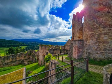 Düşük savunma duvarlarının ve Hochburg 'un temellerinin güneşli panoramik görüntüsü. Merdivenlerden bakınca, Baden 'deki en büyük kale kalıntılarından birinin geniş ölçekli olduğunu görüyoruz. Ren Vadisi ve Vosges Dağları' na bakıyor..