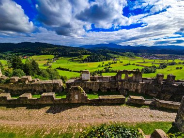 Düşük savunma duvarlarının ve Hochburg 'un temellerinin güneşli panoramik görüntüsü. Merdivenlerden bakınca, Baden 'deki en büyük kale kalıntılarından birinin geniş ölçekli olduğunu görüyoruz. Ren Vadisi ve Vosges Dağları' na bakıyor..