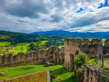 Düşük savunma duvarlarının ve Hochburg 'un temellerinin güneşli panoramik görüntüsü. Merdivenlerden bakınca, Baden 'deki en büyük kale kalıntılarından birinin geniş ölçekli olduğunu görüyoruz. Ren Vadisi ve Vosges Dağları' na bakıyor..