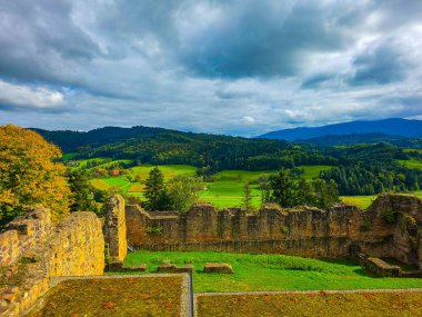 Düşük savunma duvarlarının ve Hochburg 'un temellerinin güneşli panoramik görüntüsü. Merdivenlerden bakınca, Baden 'deki en büyük kale kalıntılarından birinin geniş ölçekli olduğunu görüyoruz. Ren Vadisi ve Vosges Dağları' na bakıyor..