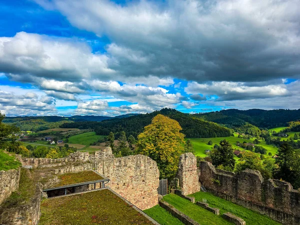Düşük savunma duvarlarının ve Hochburg 'un temellerinin güneşli panoramik görüntüsü. Merdivenlerden bakınca, Baden 'deki en büyük kale kalıntılarından birinin geniş ölçekli olduğunu görüyoruz. Ren Vadisi ve Vosges Dağları' na bakıyor..