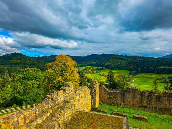 Düşük savunma duvarlarının ve Hochburg 'un temellerinin güneşli panoramik görüntüsü. Merdivenlerden bakınca, Baden 'deki en büyük kale kalıntılarından birinin geniş ölçekli olduğunu görüyoruz. Ren Vadisi ve Vosges Dağları' na bakıyor..