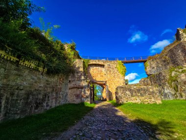 Antik taş duvarların kalıntıları ve küçük bir giriş kapısı olan güzel bir manzara. Çarpıcı, bulutlu bir gökyüzünün altındaki görkemli, büyük yaprak döken ağaca doğru bir çakıl yolu esiyor. Bu görüntü Avrupa 'nın özünü yansıtıyor.