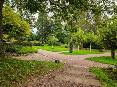 Dikdörtgen şeklinde taş basamakları olan manzaralı çakıl yürüyüş patikası sık bir ormanlık alana çıkıyor. Yol çeşitli yaprak döken ve kozalaklı ağaçlarla çevrili. Açık hava aktiviteleri ve doğa severler için sakin ve davetkar bir atmosfer yaratıyor..