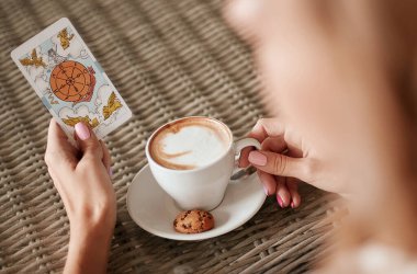 Kadının elinde bir tarot kartı var. 