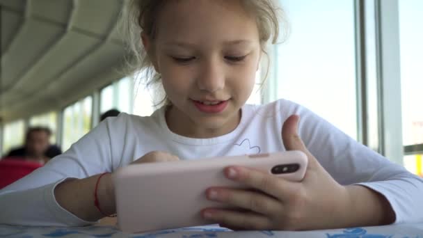 Liten Blond Flicka Med Ett Leende Spelar Lär Sig Smartphone — Stockvideo