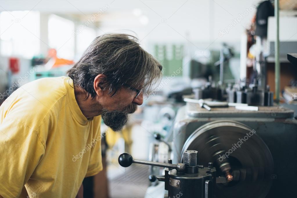 Serious man working on metalworking machine