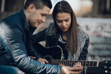 genç adam öğretim kız Çal gitar