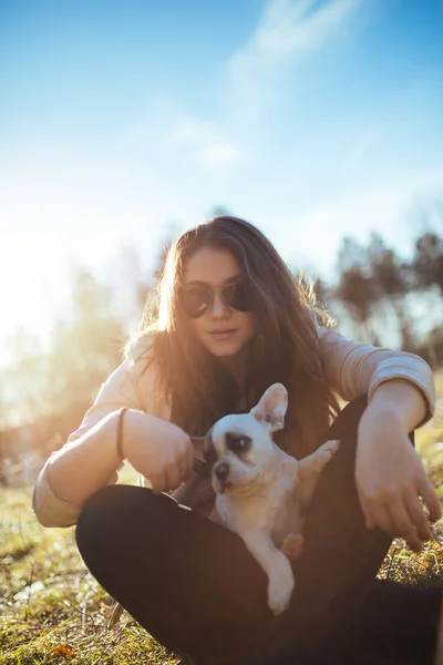 girl in sunglasses playing with puppy