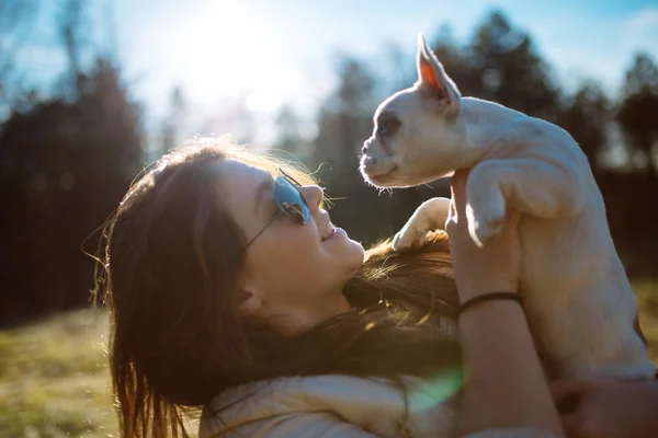 Girl in sunglasses playing with puppy — Stock Photo, Image