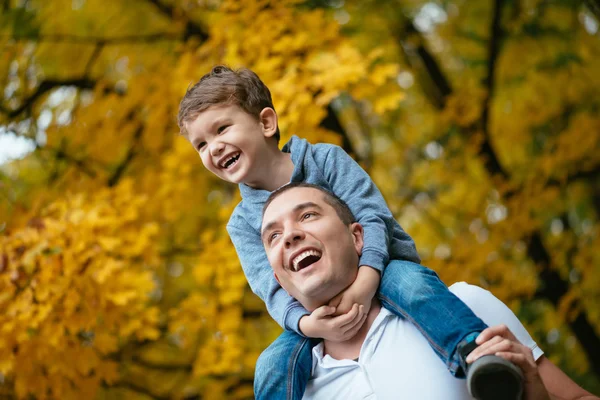 Small boy sitting on father neck — Stock Photo, Image