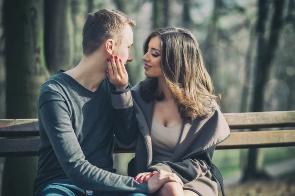 Jovem casal sentado no banco — Fotografia de Stock