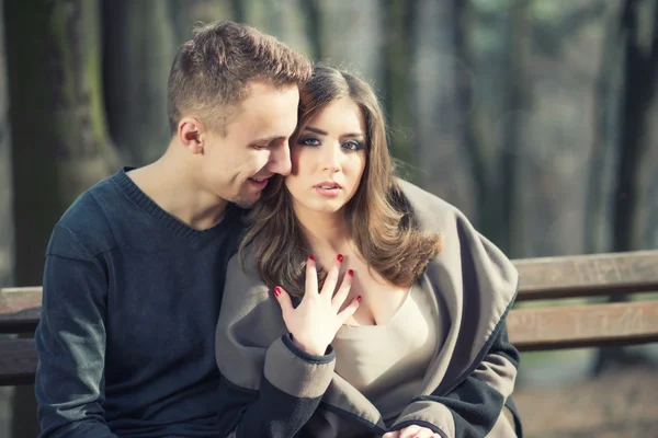 Jeune couple assis sur le banc — Photo