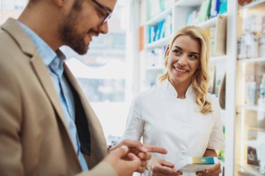 Genç bir iş adamı çekici bir kadın eczacıyla konuşurken eczanede uyuşturucu seçip alıyor. Uzman tavsiyelerinde ona yardım ediyor..