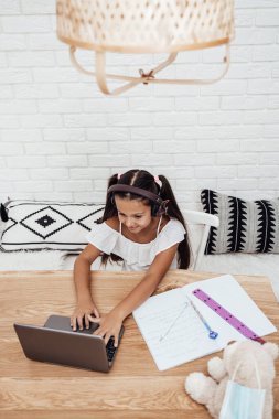 Covid-19 salgını sırasında ya da karantina sırasında e-öğrenim seansı yapan küçük bir kız. Hastalık önleme ve yeni normal kavram.