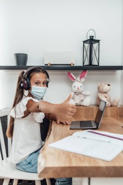 Covid-19 salgını sırasında ya da karantina sırasında e-öğrenim seansı yapan küçük bir kız. Hastalık önleme ve yeni normal kavram.