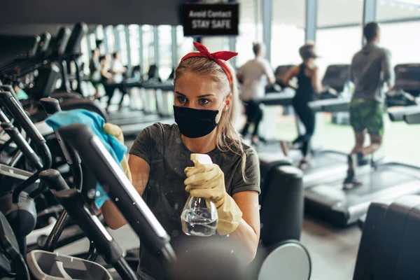 Young Female Worker Disinfecting Cleaning Weeping Expensive Fitness Gym Equipment — Stock Photo, Image