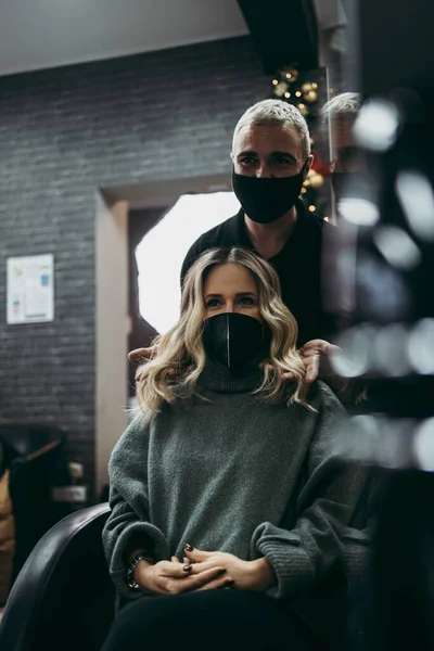 髪を染色し 美容室で強調した後の女性の美しい髪型 彼女はウイルスのパンデミックに対する保護として保護面マスクを着用している — ストック写真