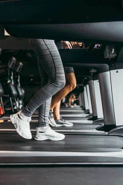 여성과 남성이 체육관에서 위에서 달리고 있습니다 움직이는 다리에 클로즈업 — 스톡 사진