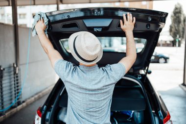 Paçavralı şapka temizleme arabalı genç yakışıklı adam, araba temizleme (ya da vale) konsepti. 