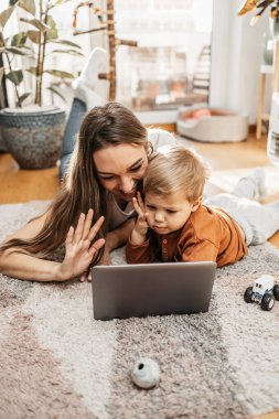 Küçük oğluyla mutlu bir anne, online görüntülü sohbet ya da aile üyeleriyle iletişim kuruyor. Karantina veya pandemik kilitleme sırasında sanal iletişim.